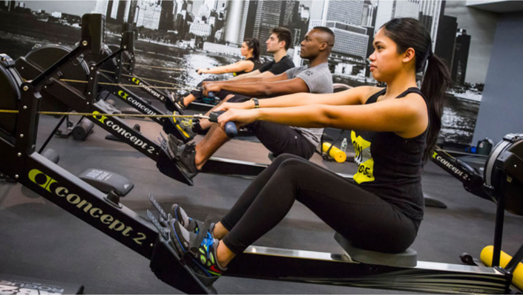 Four people using rowing machines